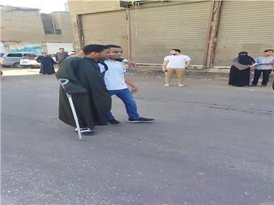 طالب يساند زميله على عكاز أثناء دخوله لجنة الثانوية العامة بقنا| صور