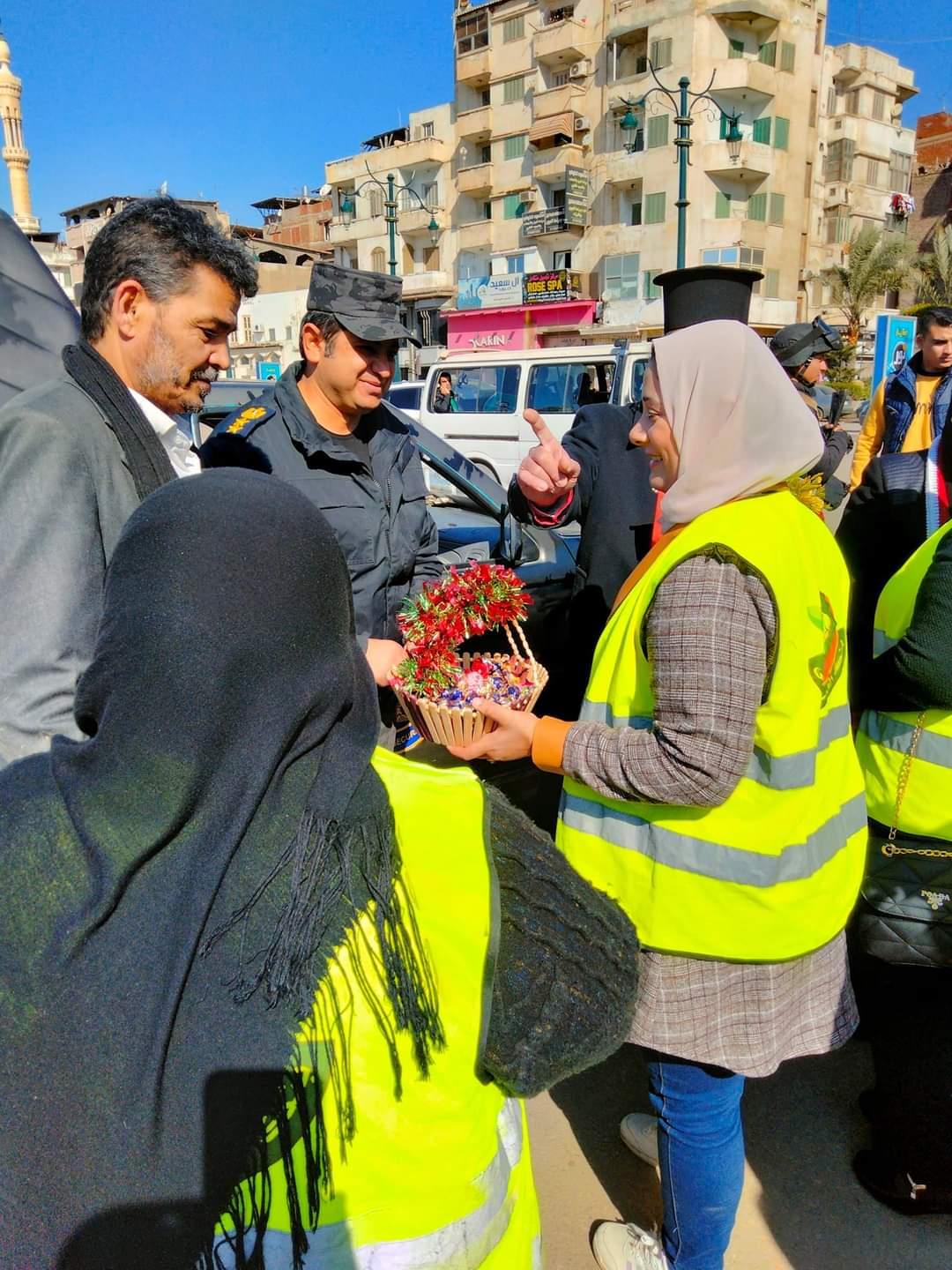 تبادل تقديم الورد بين الشرطة والمواطنين خلال احتفالات عيد الشرطة بدمياط  
