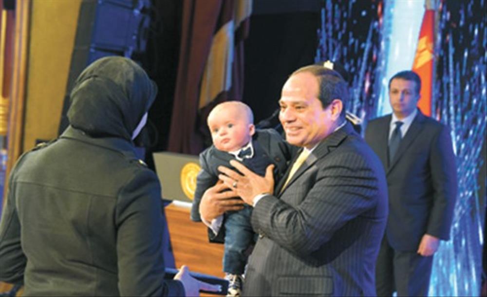 الرئيس يحتضن نجل أحد الشهداء بحنان الأب خلال الاحتفال بعيد الشرطة العام الماضي