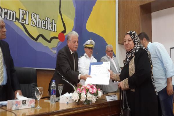 المحافظ يسلم احد المستفيدات خطاب تخصيص الوحدة السكنية