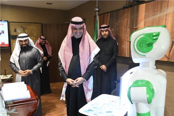الروبوت «تقني» أثناء تسلمه بطاقة التعيين
