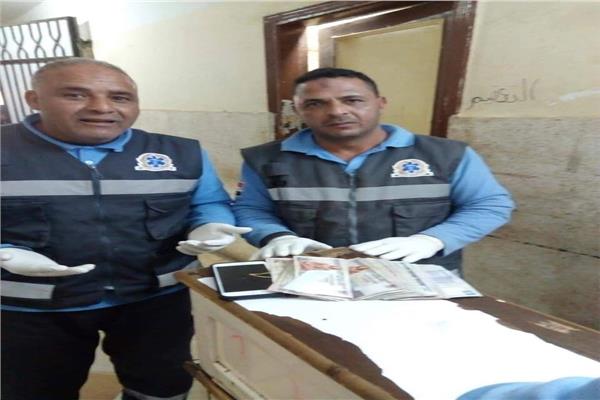 طاقم سيارة الإسعاف خلال تسليم المبلغ 