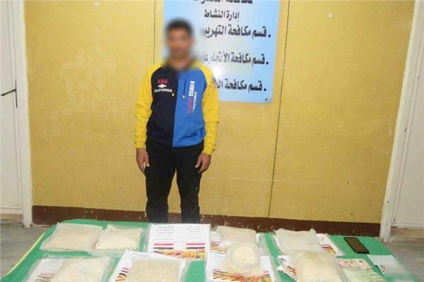 المتهم وأمامه المضبوطات