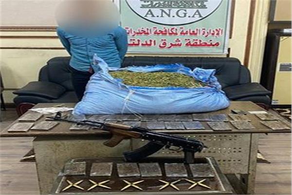 أحد المتهمين وأمامه المضبوطات