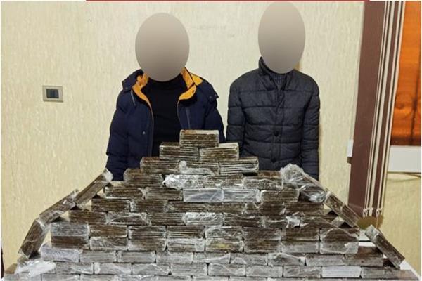 المتهمان وأمامهما المضبوطات
