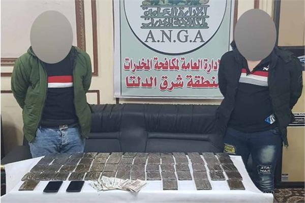 المتهمان وأمامهما المضبوطات