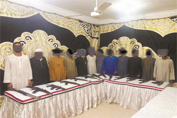  عدد من المتهمين وأمامهم الأسلحة المضبوطة