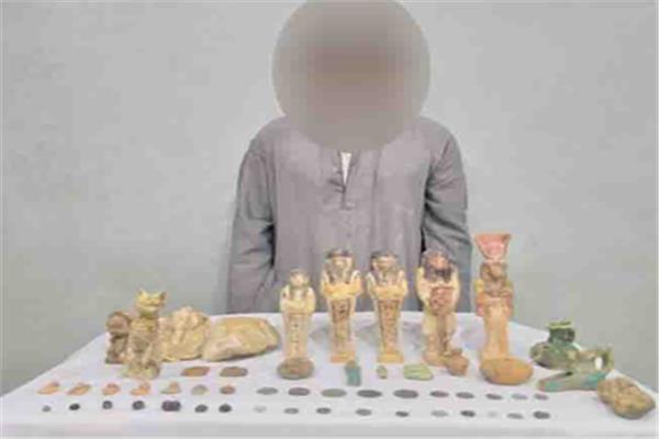 المتهم وأمامه المضبوطات