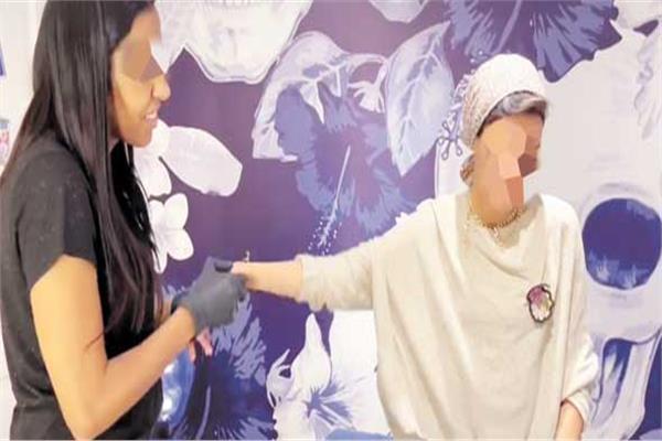 المتهمة اثناء علاجها لاحدى المريضات 