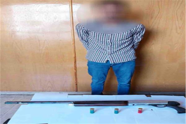 المتهم وأمامه المضبوطات