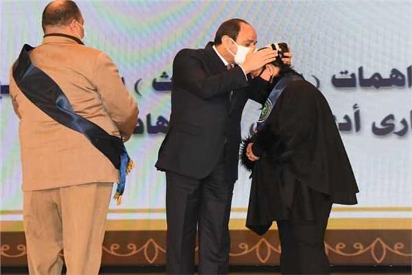 الرئيس السيسي يقبل رأس زوجة شهيد