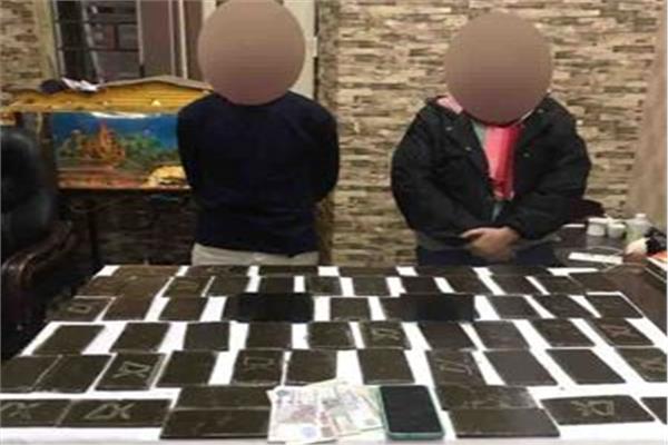 المتهمان وأمامهما المضبوطات
