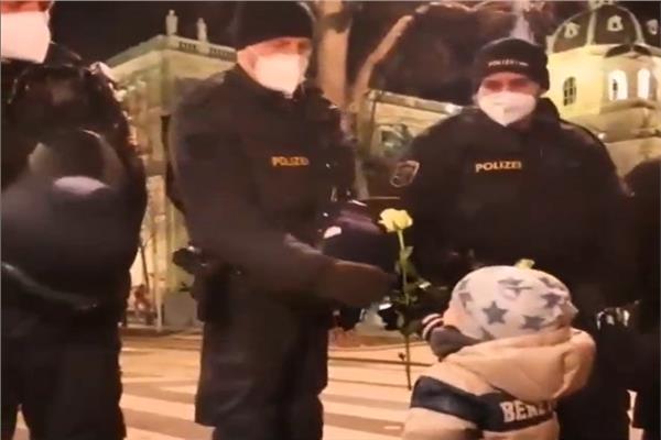 الطفل النمساوي يقوم بتوزيع الورود علي قوات مكافحة الشغب 