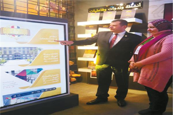 اللواء محمد سلامة  يستعرض إحدى الشاشات التفاعلية بالمعرض