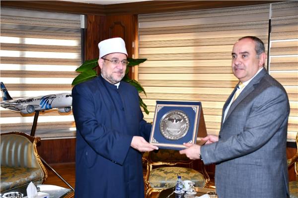 الطيار محمد منار عنبة اثناء إهداء درع وزارة الطيران المدني لوزير الأوقاف