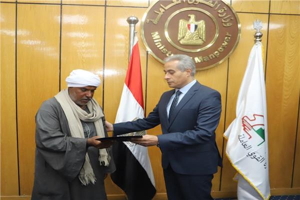 وزير القوى العاملة خلال تسليم الأهالي التعويضات