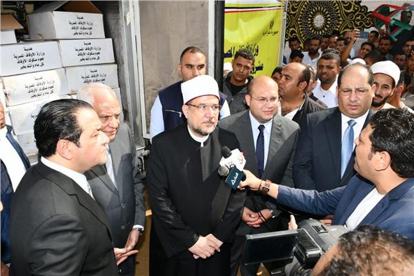 وزير الأوقاف ومحافظ الجيزة خلال توزيع 2 طن من لحوم صكوك الأوقاف 