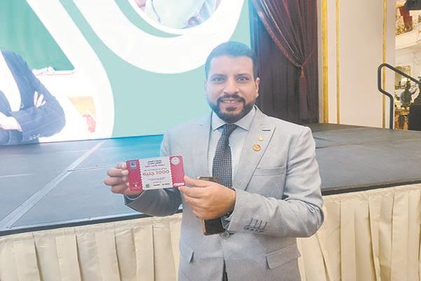 علاء الجندي أحد المعلمين المكرمين يحمل أولى بطاقات «سند المعلم»