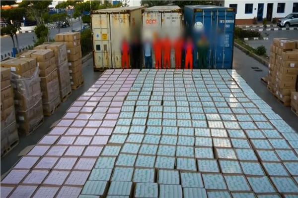 أفراد العصابة وأمامهم شحنة الأقراص المخدرة المضبوطة