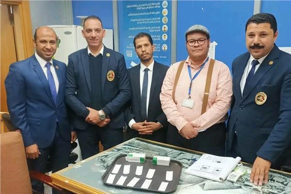 رجال الجمارك بمطار الغردقه وامامهم المضبوطات