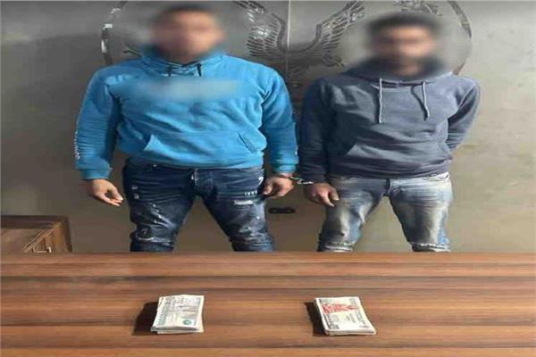 المتهمان وأمامهما المضبوطات