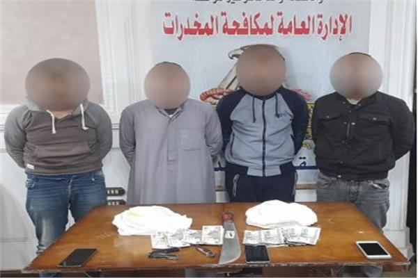 المتهمون وأمامهم المضبوطات