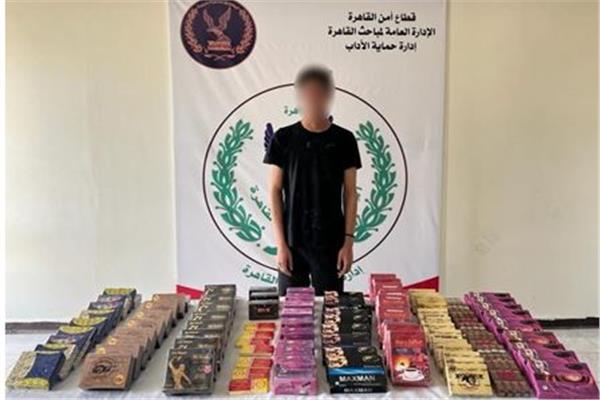 المتهم وأمامه المضبوطات