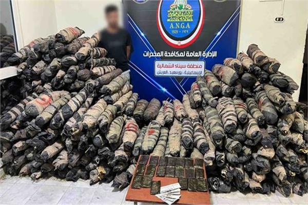 المتهم وأمامه المضبوطات