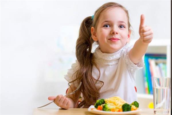 طفلة تتناول الغذاء