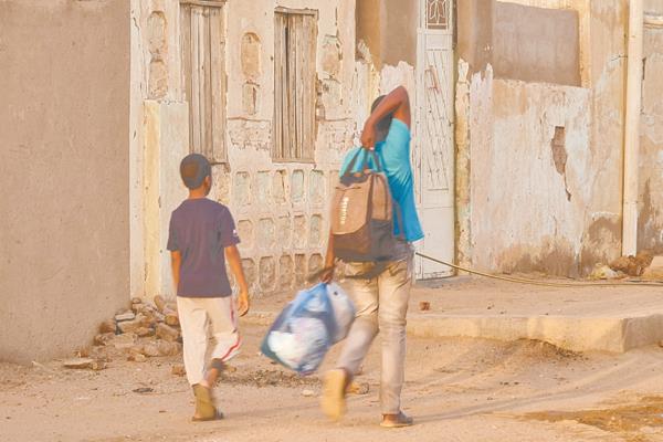 سوداني يحمل متاعه ويفر مع شقيقه من معارك الخرطوم 