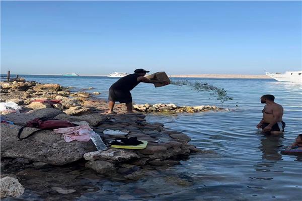 شخص يقوم بإلقاء زجاجات فارغة بمياه البحر بحرم أحد الشواطئ 