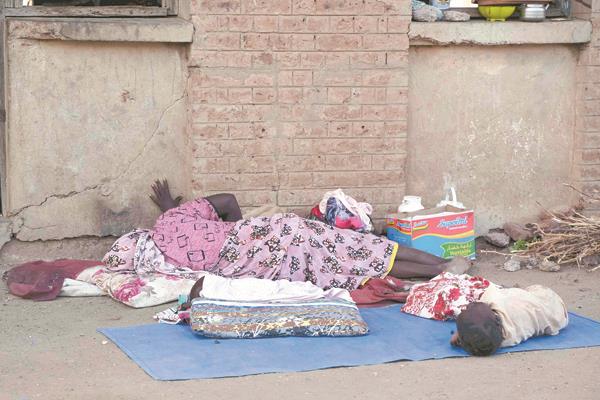 نازحة سودانية وطفلتها فى فناء مدرسة 