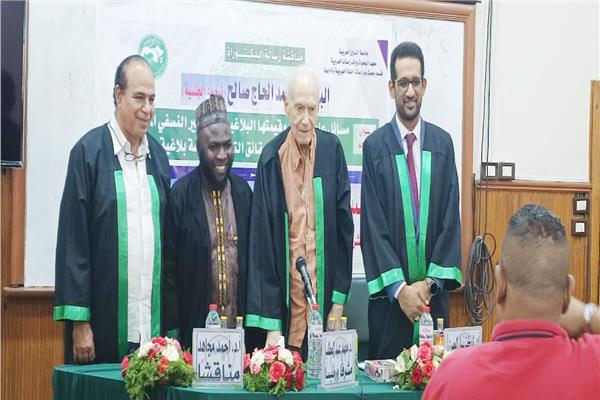 الباحث يتوسط لجنة الإشراف والمناقشة
