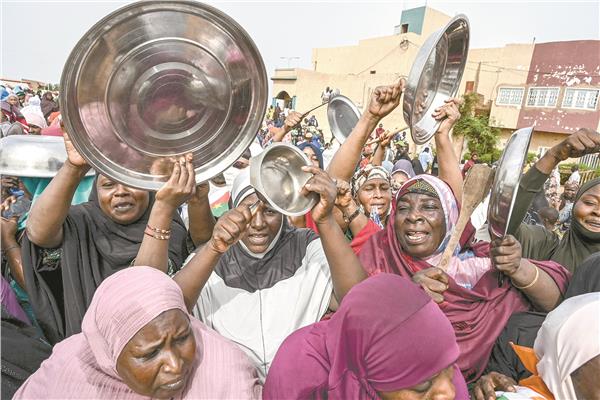 نساء يقرعن الأوانى فى محيط السفارة الفرنسية