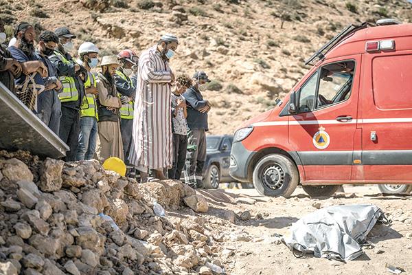 عدد من فرق الإغاثة يؤدون الصلاة على أحد ضحايا الزلزال
