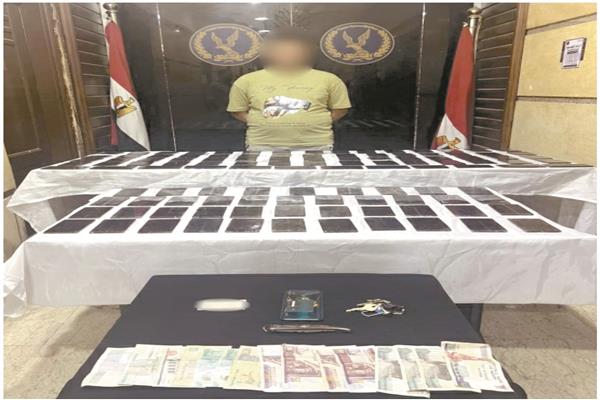 المتهم وأمامه المضبوطات