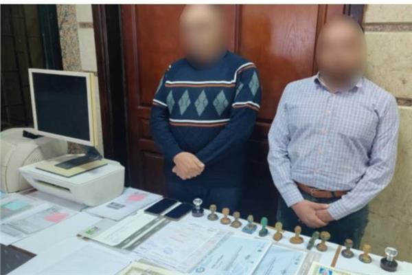 المتهمان وأمامهما المضبوطات