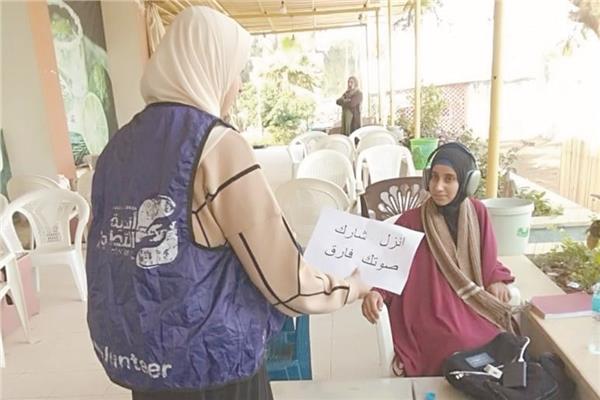 إحدى المتطوعات أثناء توزيع أوراق التوعية