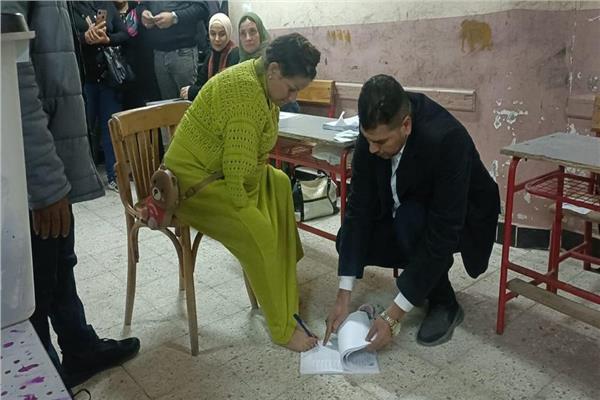 السيدة اثناء الإدلاء بصوتها