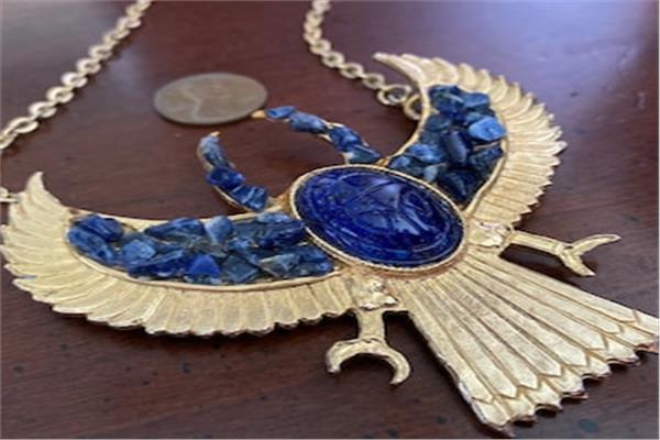 السلسلة الذهبية المزينة بالجعران الأزرق اللازورد