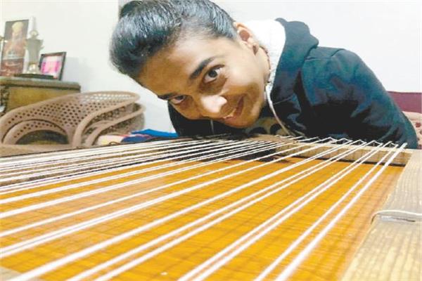 منيرة تحدت إصابتها بالشلل الدماغى وتغزل على النول بشفاهها