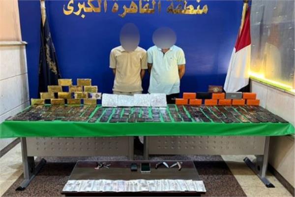 المتهمان وأمامهما المضبوطات