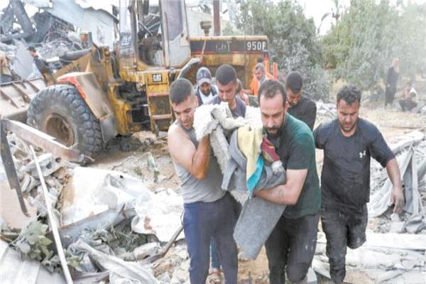 فلسطينيون يحملون أحد المصابين من موقع ضربة جوية إسرائيلية