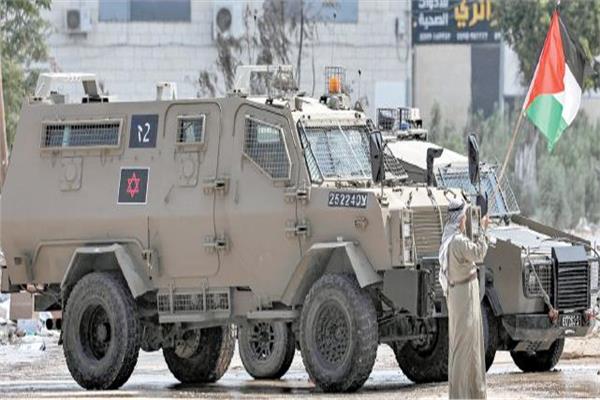 مسن يحمل العلم الفلسطينى أمام مدرعات الاحتلال فى طولكرم