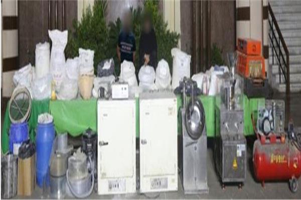 المتهمان وأمامهما المضبوطات