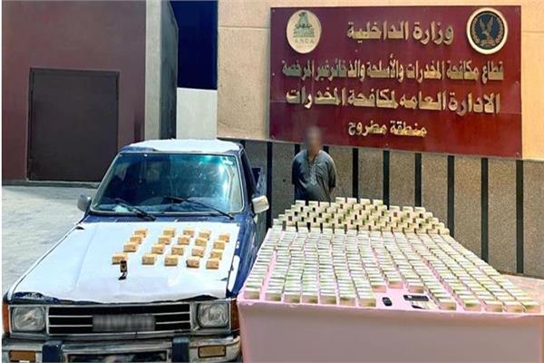 المتهم وأمامه المضبوطات