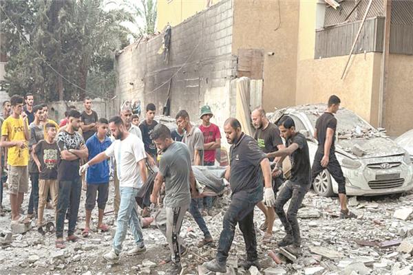 فلسطينيون يحملون أحد الشهداء جراء غارة إسرائيلية