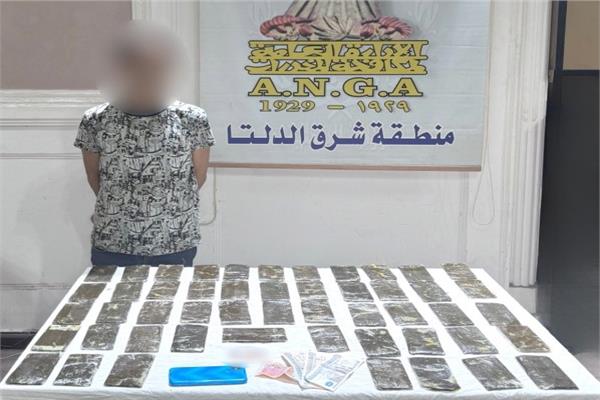 المتهم وأمامه المضبوطات