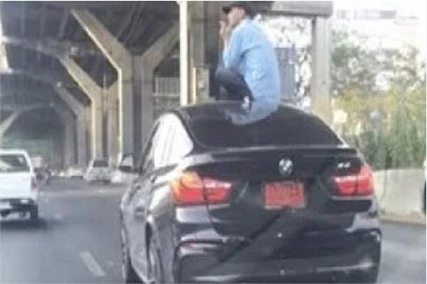 جلوس شخص علي سقف سيارة