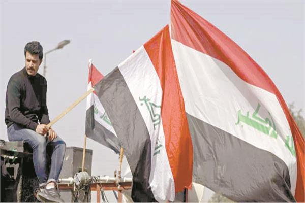متظاهرون يرفعون علم العراق احتجاجًا على مسار الانتخابات «صورة أرشيفية من أ. ف .ب»